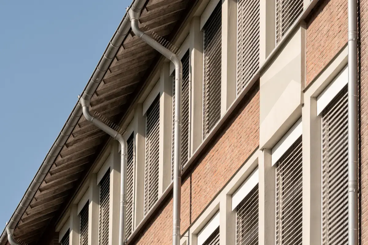 Commercial building with professional gutter installation showing metal gutters and downspouts along the roof edge