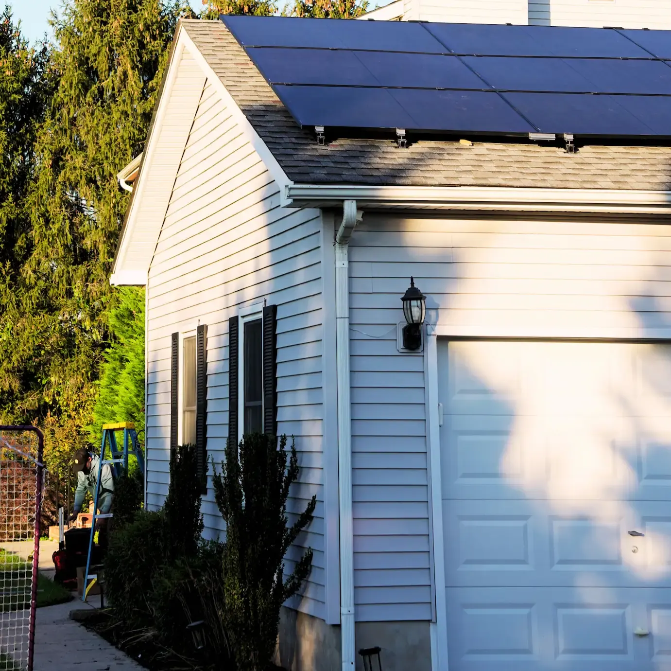 Home with clean white siding and rooftop solar installed by Sundra