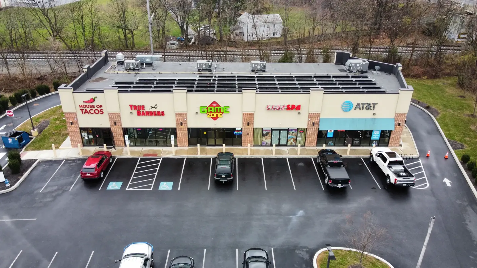 Aerial view of a retail center with a rooftop solar array above the storefronts